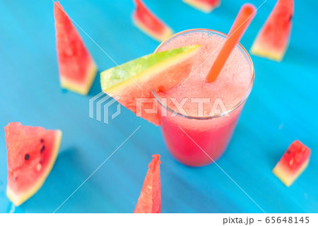 watermelon smoothie in a transparent glass with a cocktail straw on a blue background 65648145