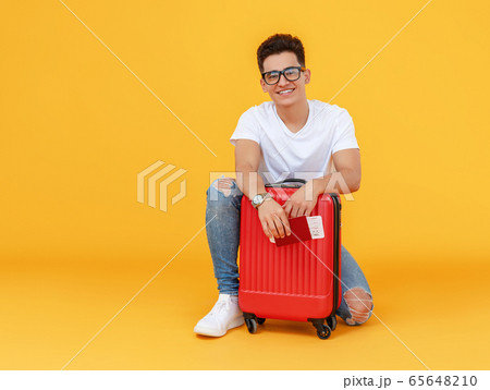 Cheerful male traveler with suitcase 65648210