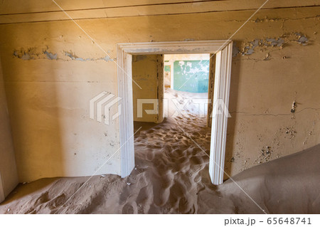 Abandoned and forgotten building and room left by people and being taken over by encroaching sandstorm, Kolmanskop ghost town, Namib Desert Abandoned and forgotten building and room left by people and being taken over by encroaching sandstorm, Kolmanskop ghost town, Namib Desert 65648741