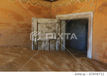 Abandoned and forgotten building and room left by people and being taken over by encroaching sandstorm, Kolmanskop ghost town, Namib Desert 65648752