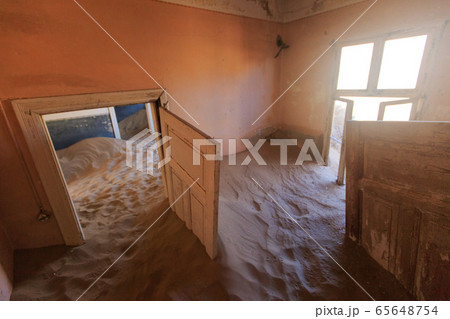 Abandoned and forgotten building and room left by people and being taken over by encroaching sandstorm, Kolmanskop ghost town, Namib Desert 65648754
