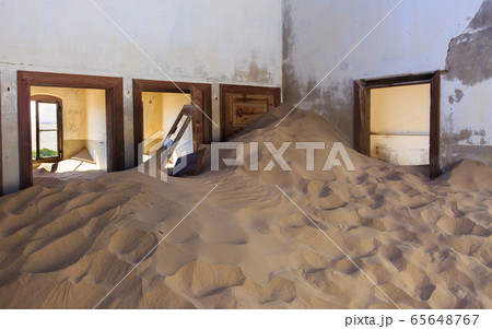 Abandoned and forgotten building and room left by people and being taken over by encroaching sandstorm, Kolmanskop ghost town, Namib Desert 65648767