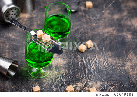 Glass of absinthe with cane sugar 65649182