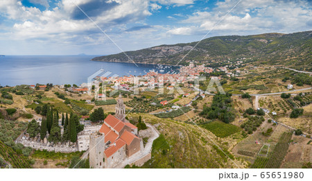 Aerial panoramic view of the cathedral St.Nicholas in Komiza city - the one of numerous port towns in Croatia, orange roofs of houses, picturisque bay, mountain is on background Aerial panoramic view of the cathedral St.Nicholas in Komiza city - the one of numerous port towns in Croatia, orange roofs of houses, picturisque bay, mountain is on background 65651980