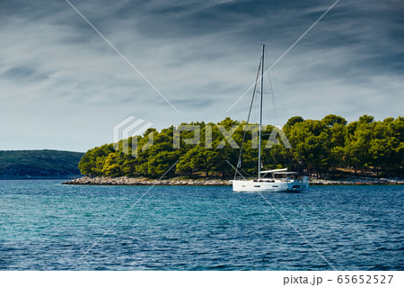 Beautiful sea landscape with lonely boat on the horizon, island is on background, bright colors 65652527