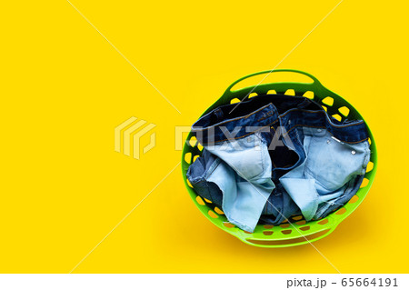 Jeans in green laundry basket  65664191