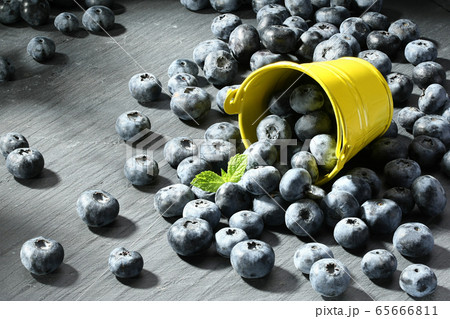 ripe blueberries in a small bucket on a gray 65666811
