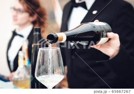 Sommlier serving a glass of sparkling wine in Alba Sommlier serving a glass of sparkling wine in Alba 65667267