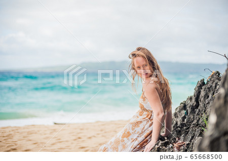 A girl sits on a rock on the beach of Boracay 65668500