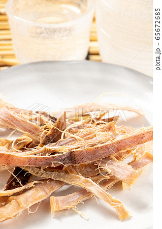 あたりめ(するめ)。写真奥にはガラス製の酒器。夏の日本酒･冷酒のおつまみイメージ。 65672685