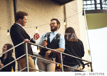 Group of young caucasian people celebrating, look happy, have corporate party at office or bar Group of young caucasian people celebrating, look happy, have corporate party at office or bar 65675709