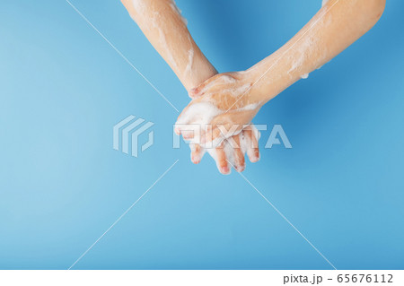 Children's hands in soap suds, on a blue Children's hands in soap suds, on a blue 65676112