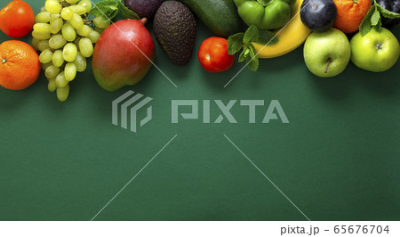 Fresh fruits and vegetables over green background, 65676704