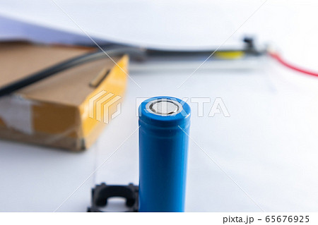 Blue lithium ion battery which placed vertically with blurred background. Blue lithium ion battery which placed vertically with blurred background. 65676925