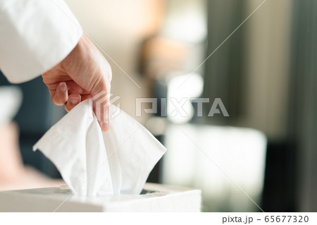 women hand picking napkin/tissue paper from the tissue box 65677320