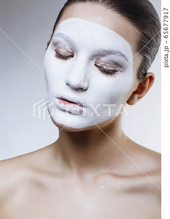 pretty caucasian girl in white mask on face, cosmetic spa concept pretty caucasian girl in white mask on face, cosmetic spa concept 65677917