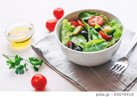 Fresh salad of avocado, cherry, arugula and olives made at home. 65678418