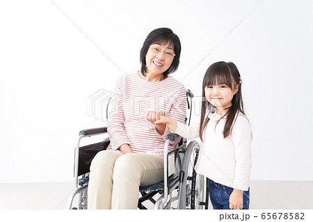 車椅子に乗るおばあちゃんと女の子 車椅子に乗るおばあちゃんと女の子 65678582