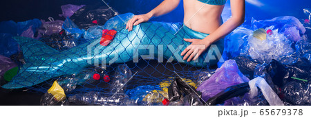 Close-up of fairytale mermaid in polluted ocean. Plastic trash and garbage in water. Environmental problem, plastic bag and bottles polluting a coral reef. Close-up of fairytale mermaid in polluted ocean. Plastic trash and garbage in water. Environmental problem, plastic bag and bottles polluting a coral reef. 65679378