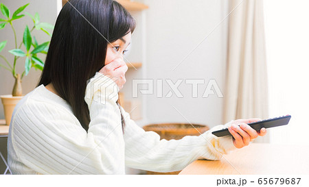 テレビを見る女性　口を抑える　コピースペース　16:9 65679687