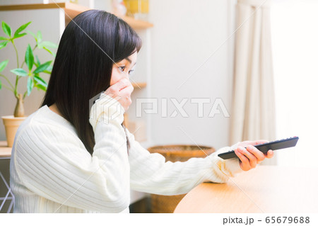 テレビを見る女性　口を抑える　コピースペース 65679688