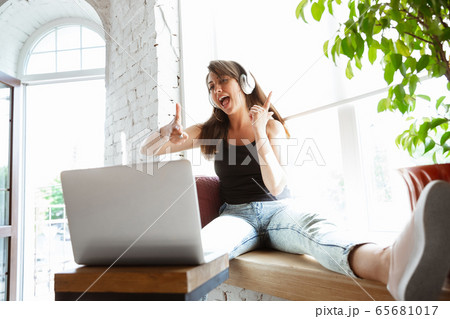 Caucasian female singer during online concert at home insulated and quarantined, cheerful and happy, singing live, performing Caucasian female singer during online concert at home insulated and quarantined, cheerful and happy, singing live, performing 65681017