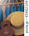 straw hat and ukulele on a hammock 65682109