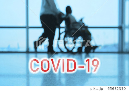 COVID-19 billboard red text on blue medical hospital background with doctor walking with disabled patient in wheelchair 65682350