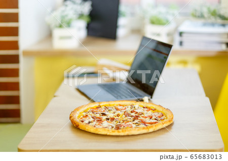 Pizza stands on a table in a cafe. 65683013