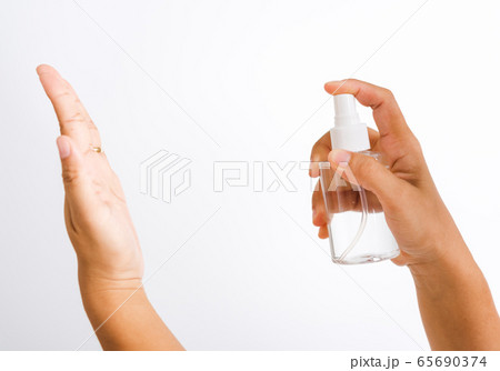woman applying spray pump dispenser sanitizer woman applying spray pump dispenser sanitizer 65690374
