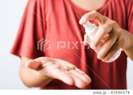 woman applying spray pump dispenser sanitizer woman applying spray pump dispenser sanitizer 65690378