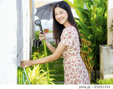 Portrait of beautiful asian woman watering green Portrait of beautiful asian woman watering green 65691344