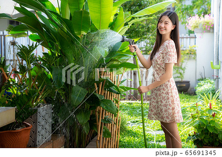 Portrait of beautiful asian woman watering green 65691345