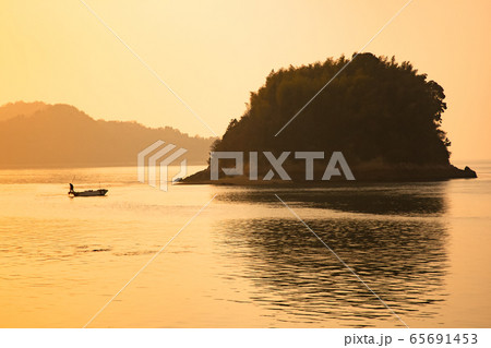 夕焼けの中で漁をする漁師シルエット風景です。広島県 夕焼けの中で漁をする漁師シルエット風景です。広島県 65691453