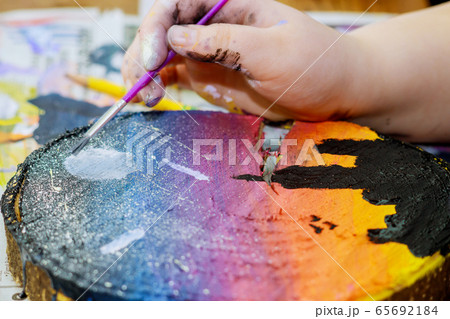 Girl uses colored paints brushes a picture in Girl uses colored paints brushes a picture in 65692184
