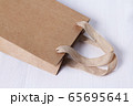 Packaging template mock up. Handle made of natural materials. Part of the package. Disposable small craft paper bag for takeaway on white table in the interior. Flatlay mock up. Place for text 65695641