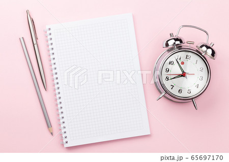 Pink workplace with supplies and alarm clock 65697170