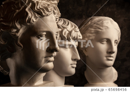 Group gypsum busts of ancient statues human heads for artists on a dark background. Plaster sculptures of antique people faces. Renaissance epoch style. Academic subject. Blank for creativity. Group gypsum busts of ancient statues human heads for artists on a dark background. Plaster sculptures of antique people faces. Renaissance epoch style. Academic subject. Blank for creativity. 65698456