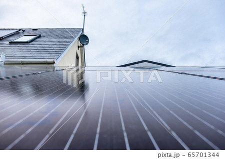 Photovoltaic panels installed on a rack next to house with solar panels for hot water 65701344