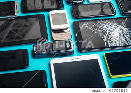 dirty, broken and old smartphones on a blue background 65701816