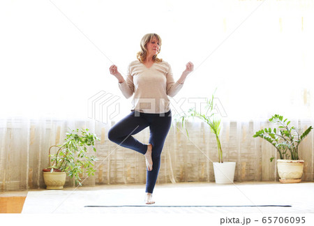 Mature woman stretching body on floor Mature woman stretching body on floor 65706095