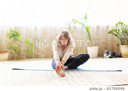 Mature woman stretching body on floor Mature woman stretching body on floor 65706096