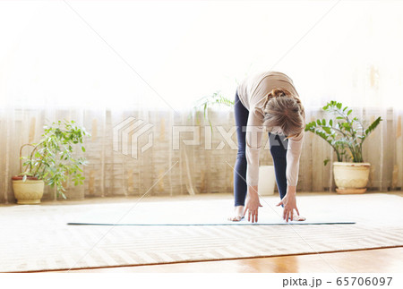 Mature woman stretching body on floor Mature woman stretching body on floor 65706097