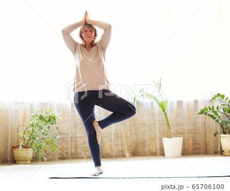 Mature woman stretching body on floor Mature woman stretching body on floor 65706100