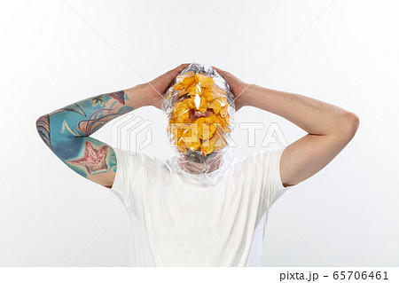 Male face covered with oilcloth, cellophane and unhealthy food, hard to breathe. People lost their faces, can't notice the environmental pollution made by themself. Male face covered with oilcloth, cellophane and unhealthy food, hard to breathe. People lost their faces, can't notice the environmental pollution made by themself. 65706461