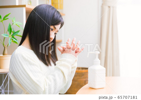 アルコール除菌する女性　手指消毒スプレー　コピースペース 65707181