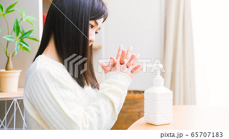 アルコール除菌する女性　手指消毒スプレー　コピースペース　16:9 65707183