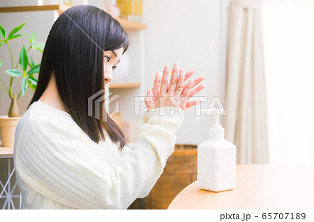アルコール除菌する女性　手指消毒スプレー　コピースペース 65707189