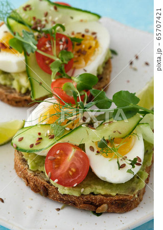 Healthy Breakfast with Wholemeal Bread Toast and Egg with Green Salad, Avocado and Peas. 65707421