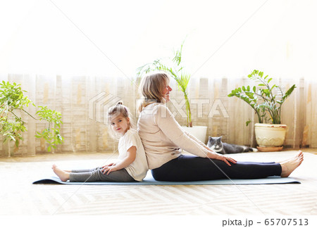 Grandmother and granddaughter meditating together 65707513